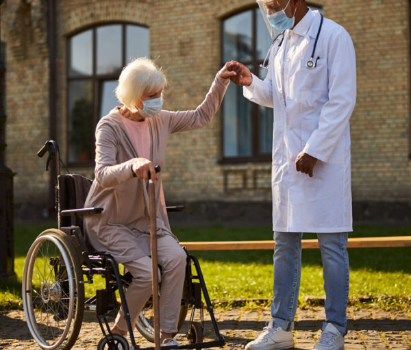 Patient in wheelchair with Doctor in park.